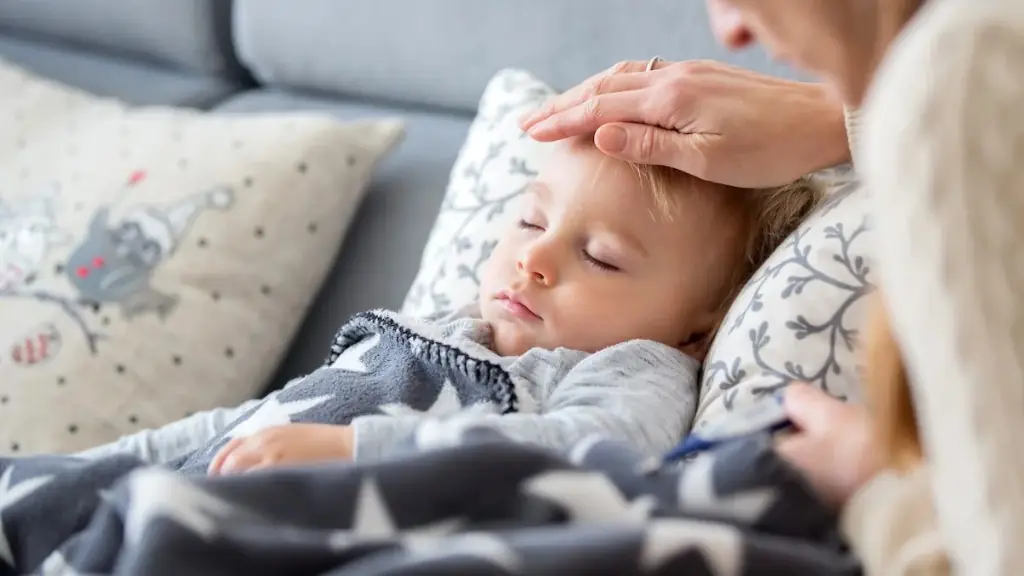 Parent checking a toddler’s forehead for fever during childhood illness care at Tiny Totz Kids Clinic in Puppalguda, Hyderabad