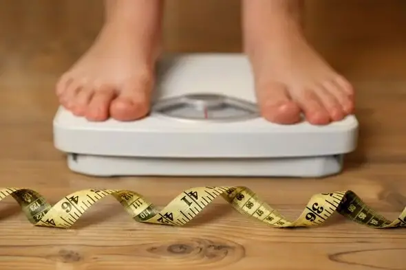 Child standing on a weight scale during obesity and puberty consultation at Tiny Totz Kids Clinic in Puppalguda, Hyderabad
